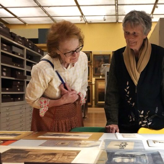 Two older women looking at Old Manchester photographs