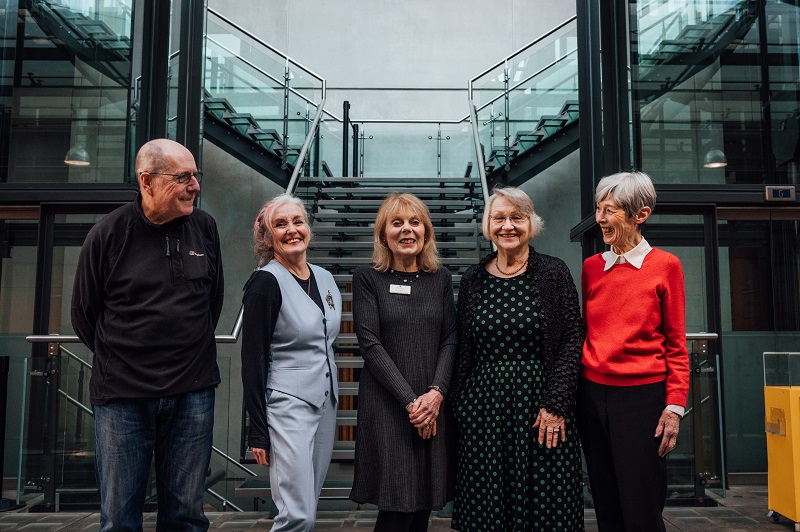 Group image of 5 volunteers stood in front of the galls stairs in the atrium