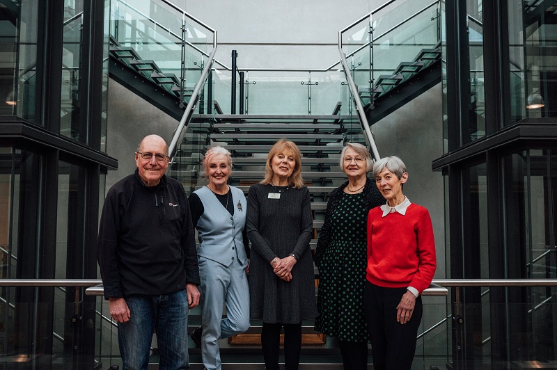 Group image of 5 volunteers stood in front of the glass stairs in the Atrium.