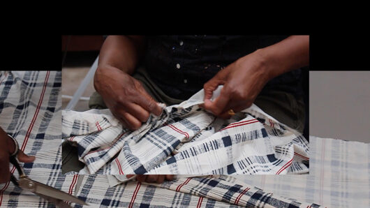 Holly Graham - Film still. Hands stitching a check patterned fabric