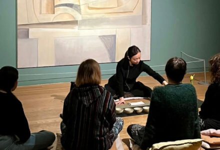 Chinese Tea Ceremony - people sat around a large artwork in a semi circle