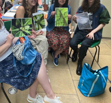 a group of young visitors sitting in a semicircle shows four vegetable illustrations